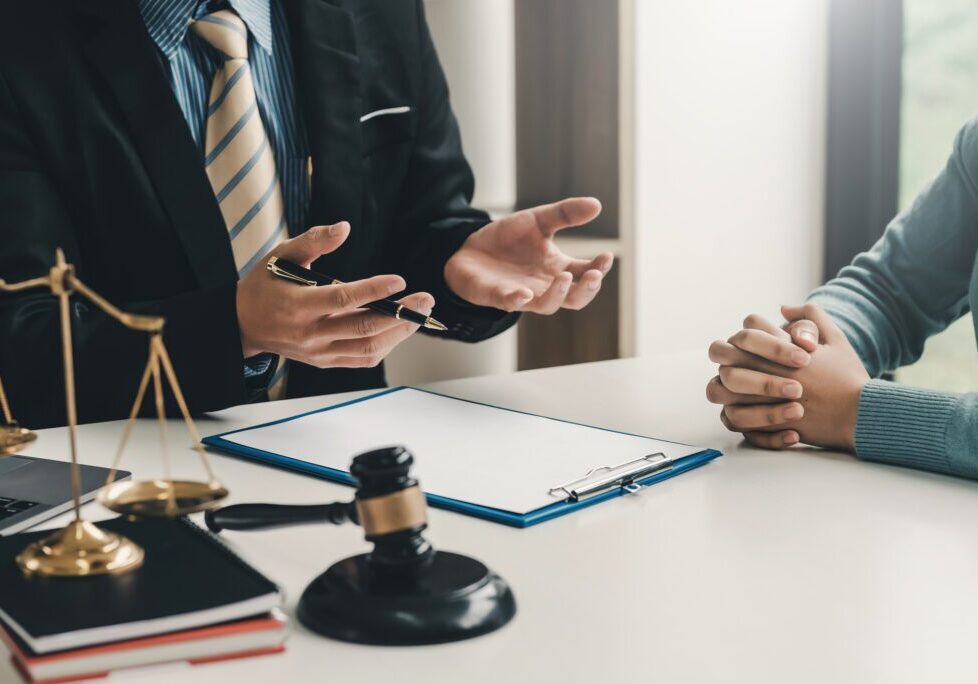 Lawyer consulting client with legal documents.